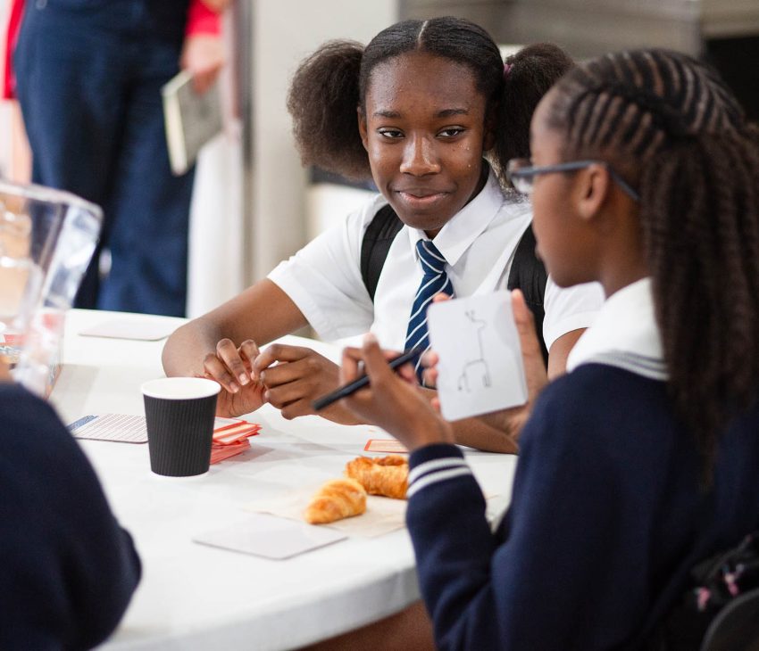 girls in school uniform eating breakfast and playing cards