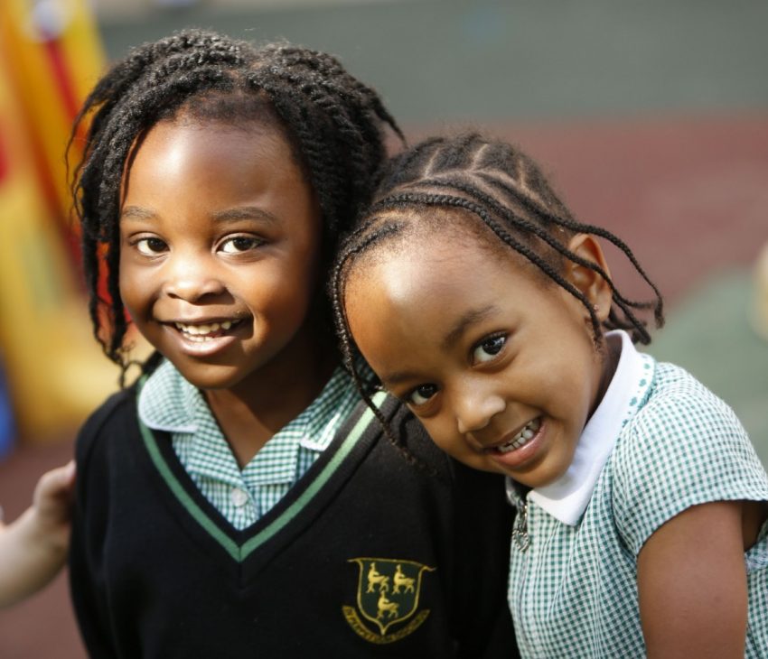 two children in school uniform smiling