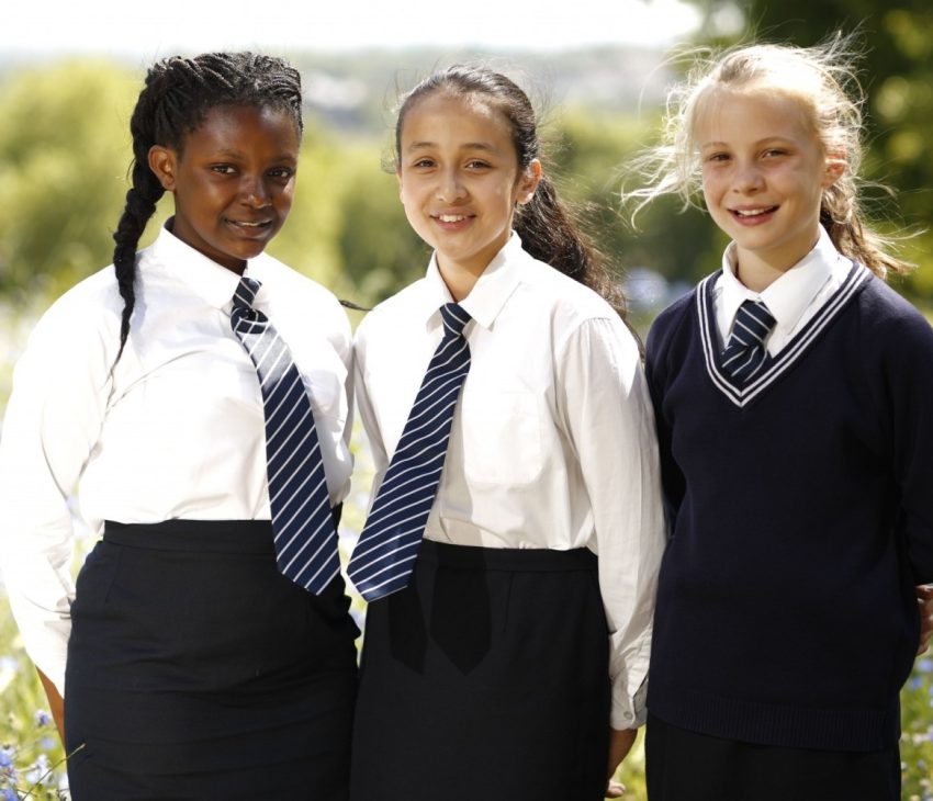 schoolchildren standing in a field in the sun