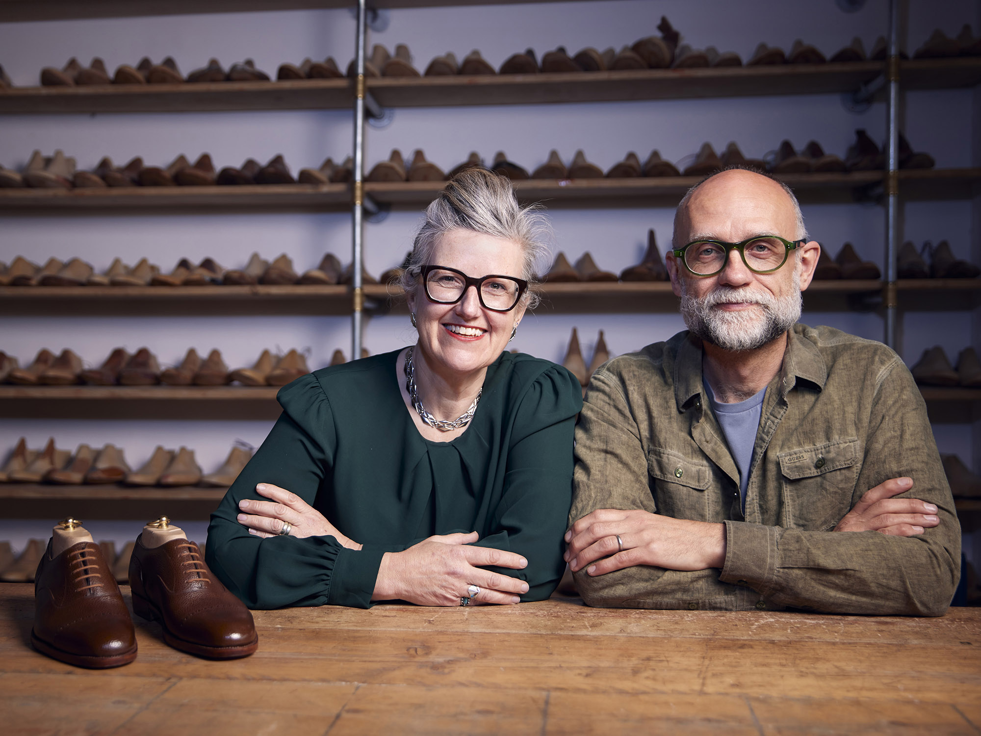 man and woman with a pair of shoes in front of them