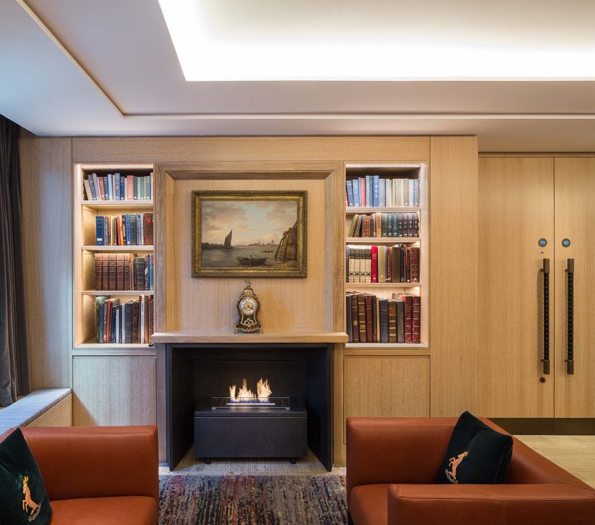 a fireplace with two leather chairs