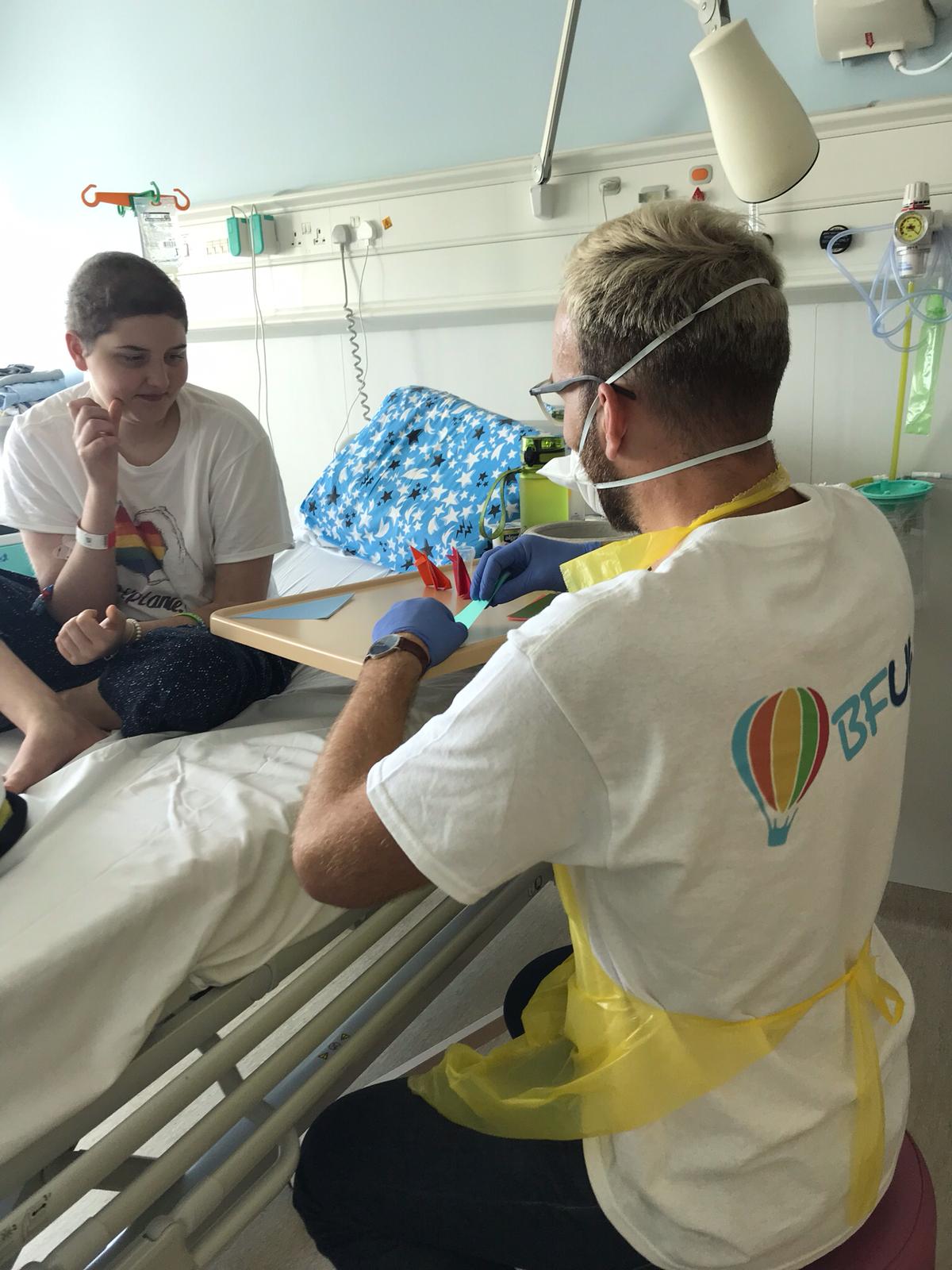 man playing with a child on a hospital bed