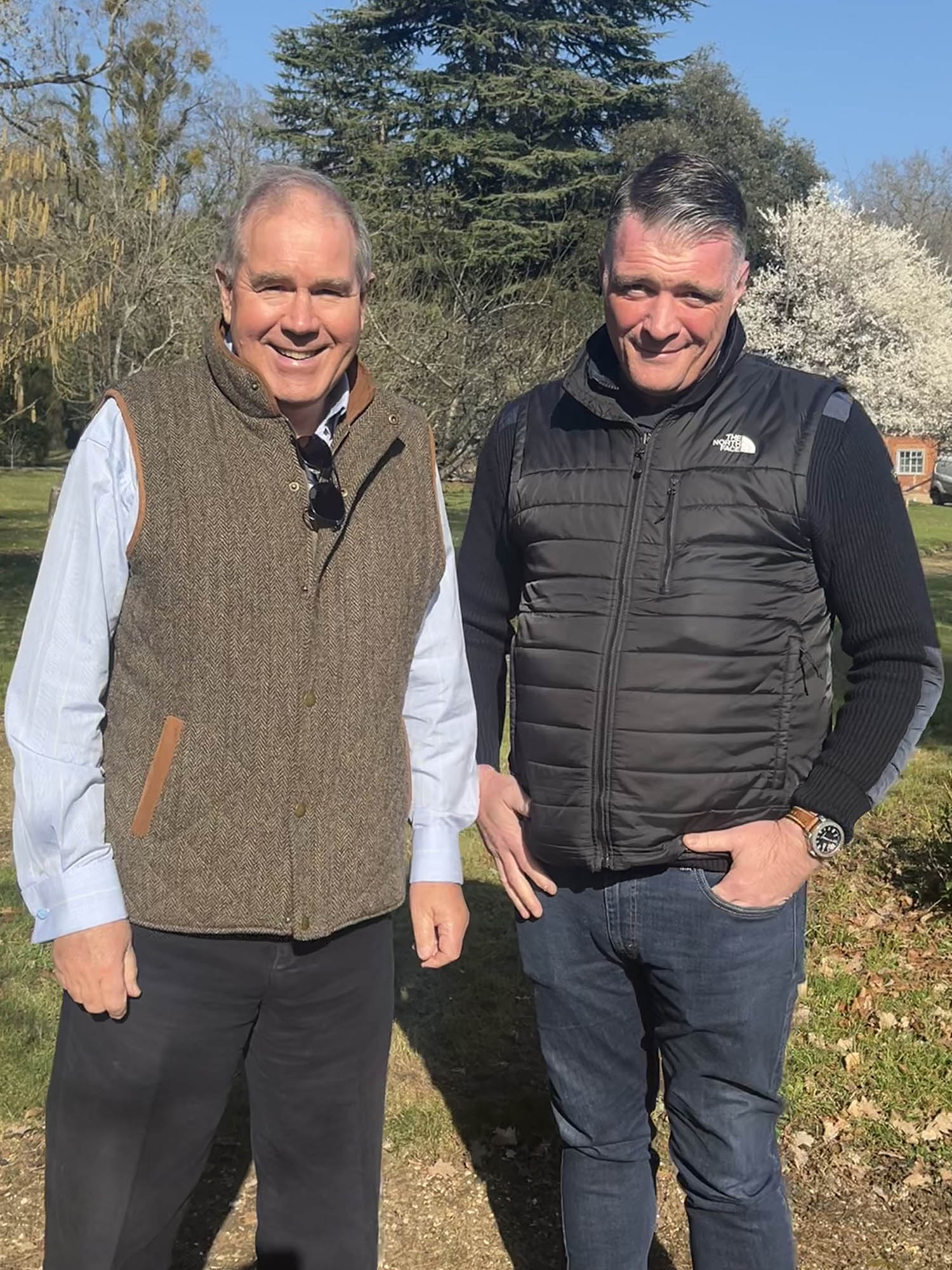 two man standing on a field with trees in the background