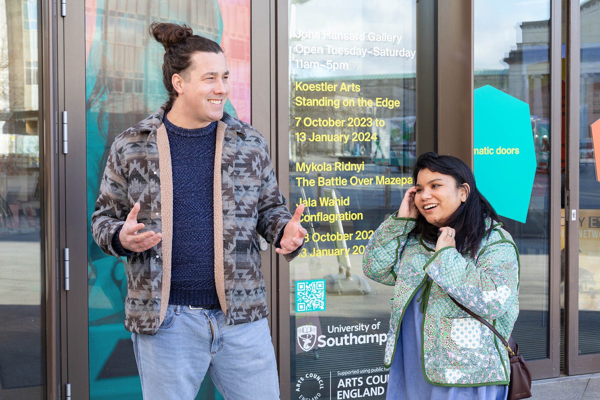 man and a woman standing outside of a gallery