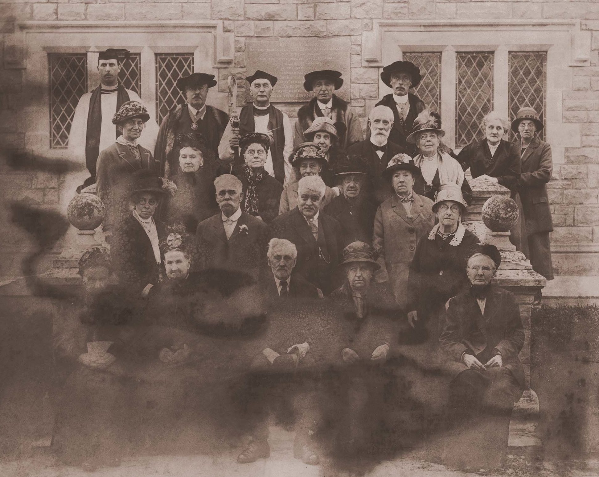 people dressed in period clothes in front of a stone building