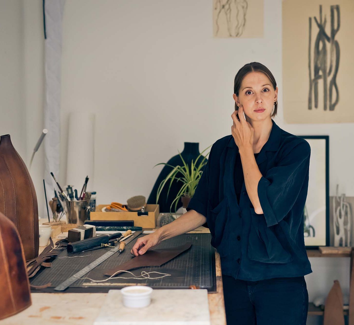 woman in a studio with leather sculptures