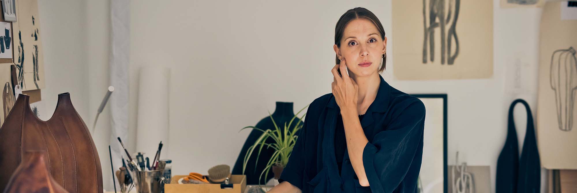 woman in a studio with leather sculptures