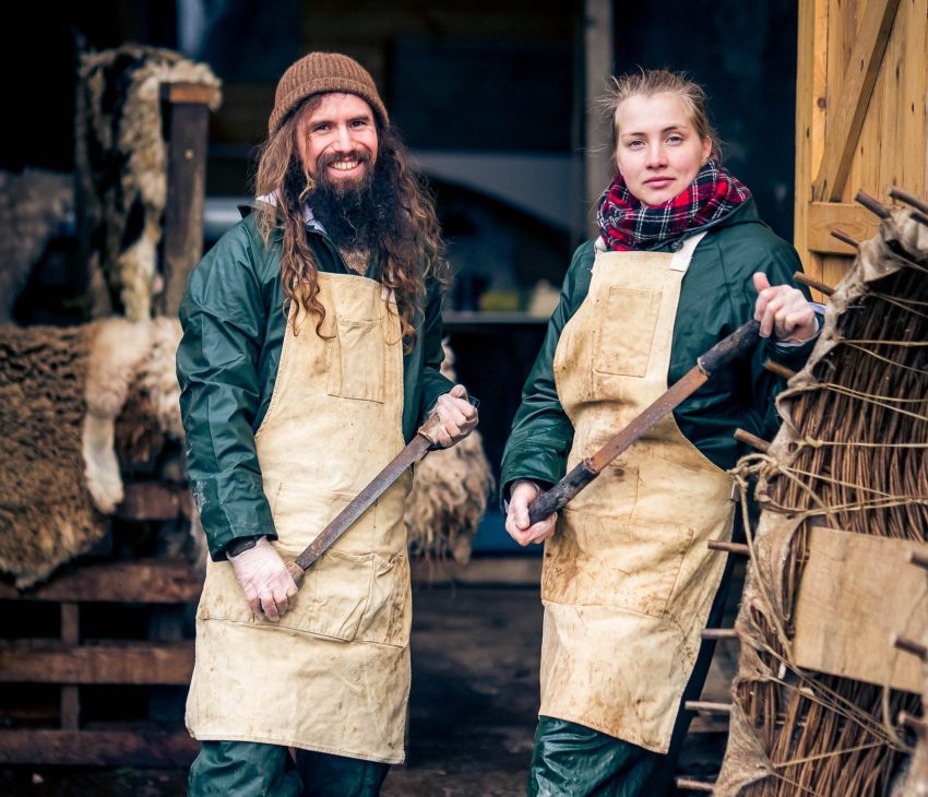 man and a woman wearing overalls and aprons