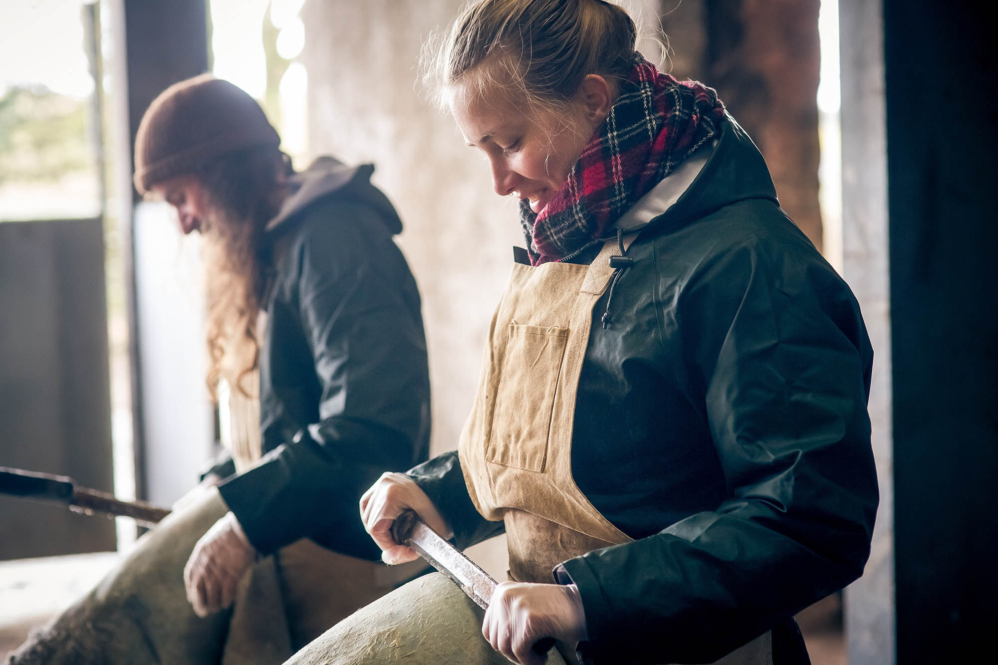 a man and woman fleshing leather