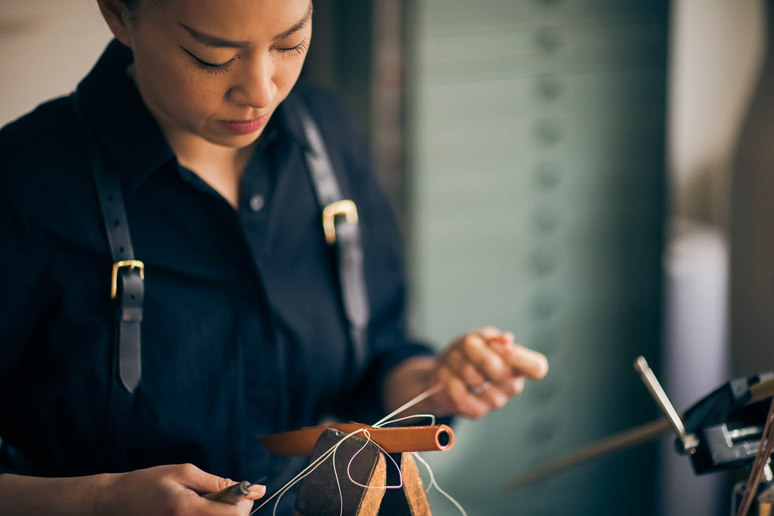 woman hand-stitching leather