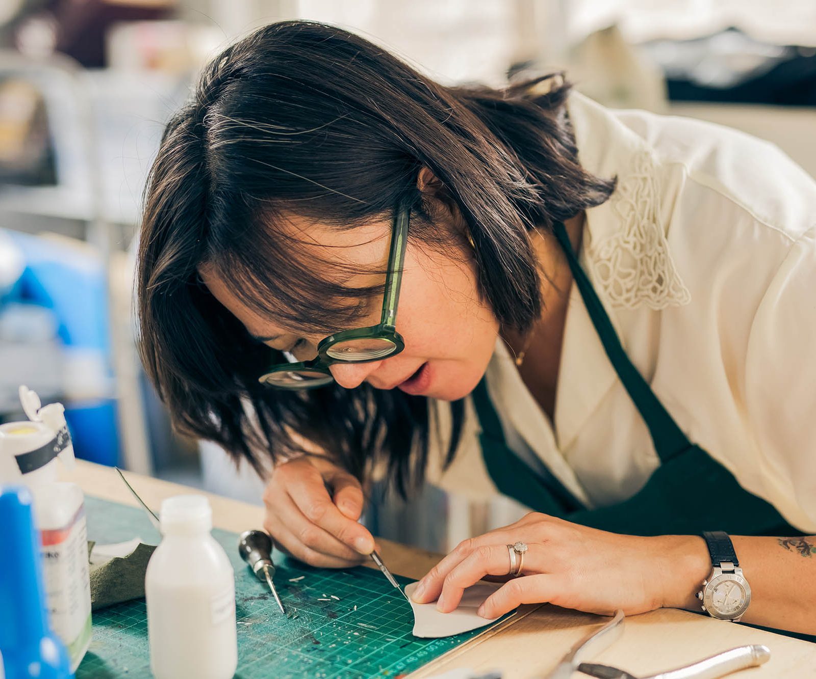woman at a bench working with leather