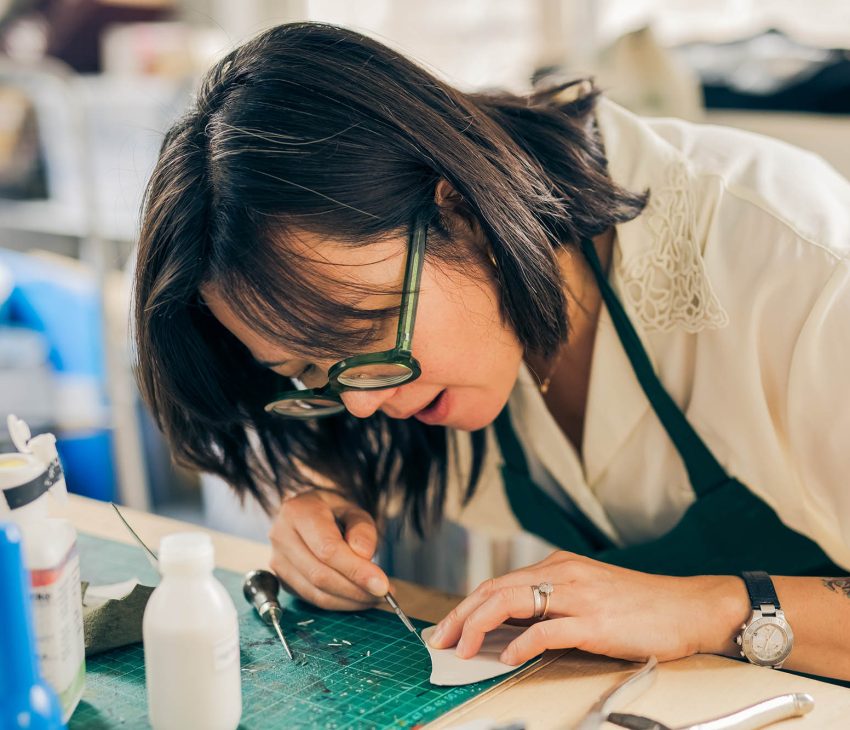 woman at a bench working with leather
