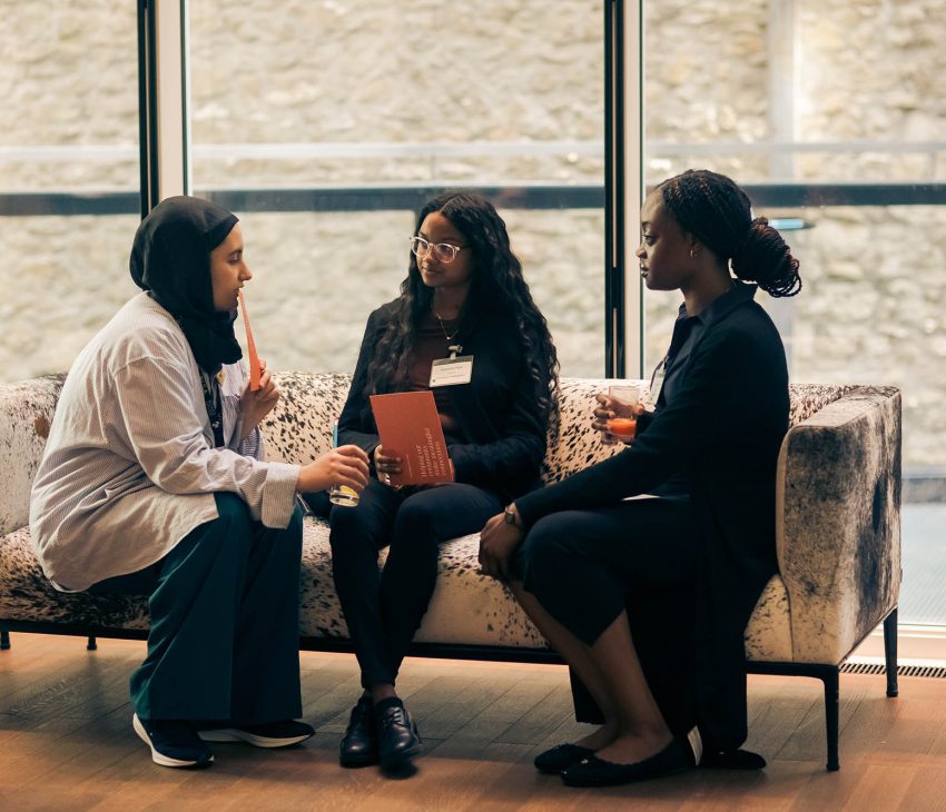 Three women sitting on a sofa talking