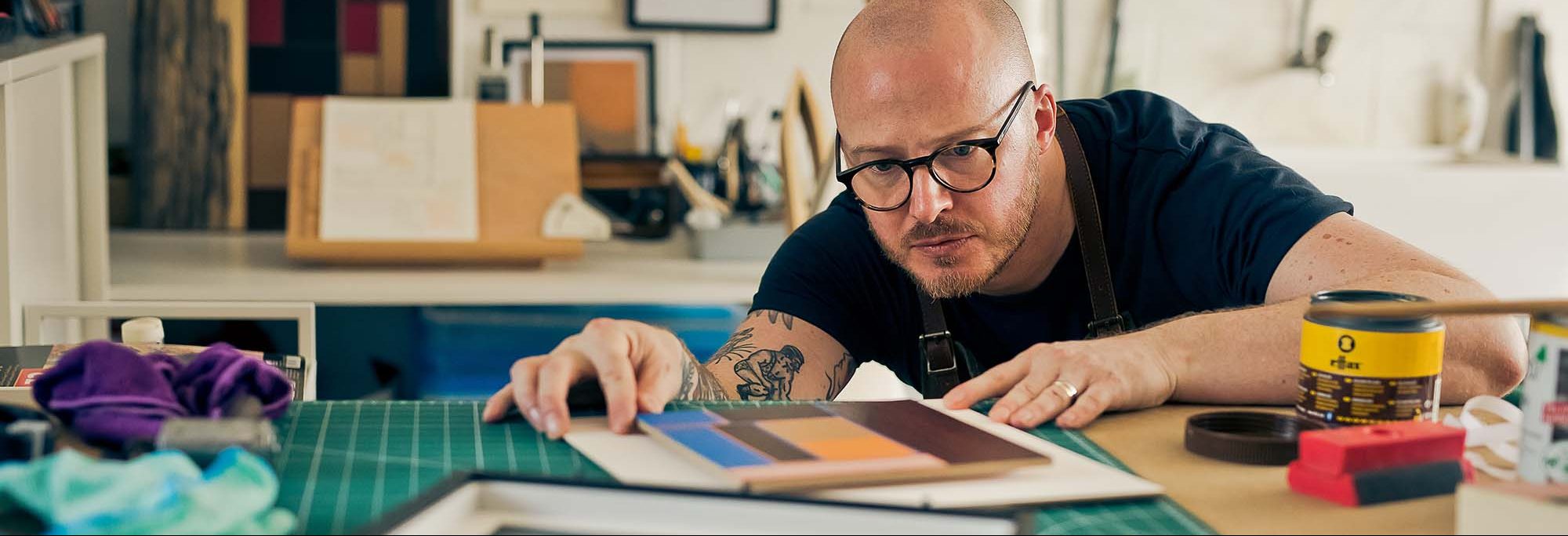 man making leather artwork in a studio