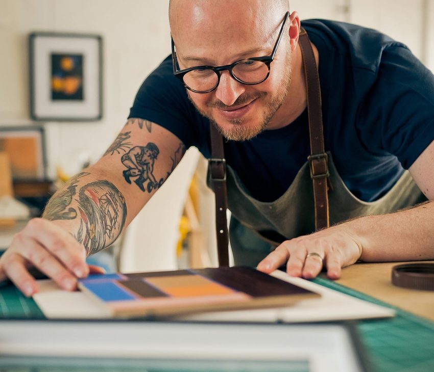 man with an apron working at a desk
