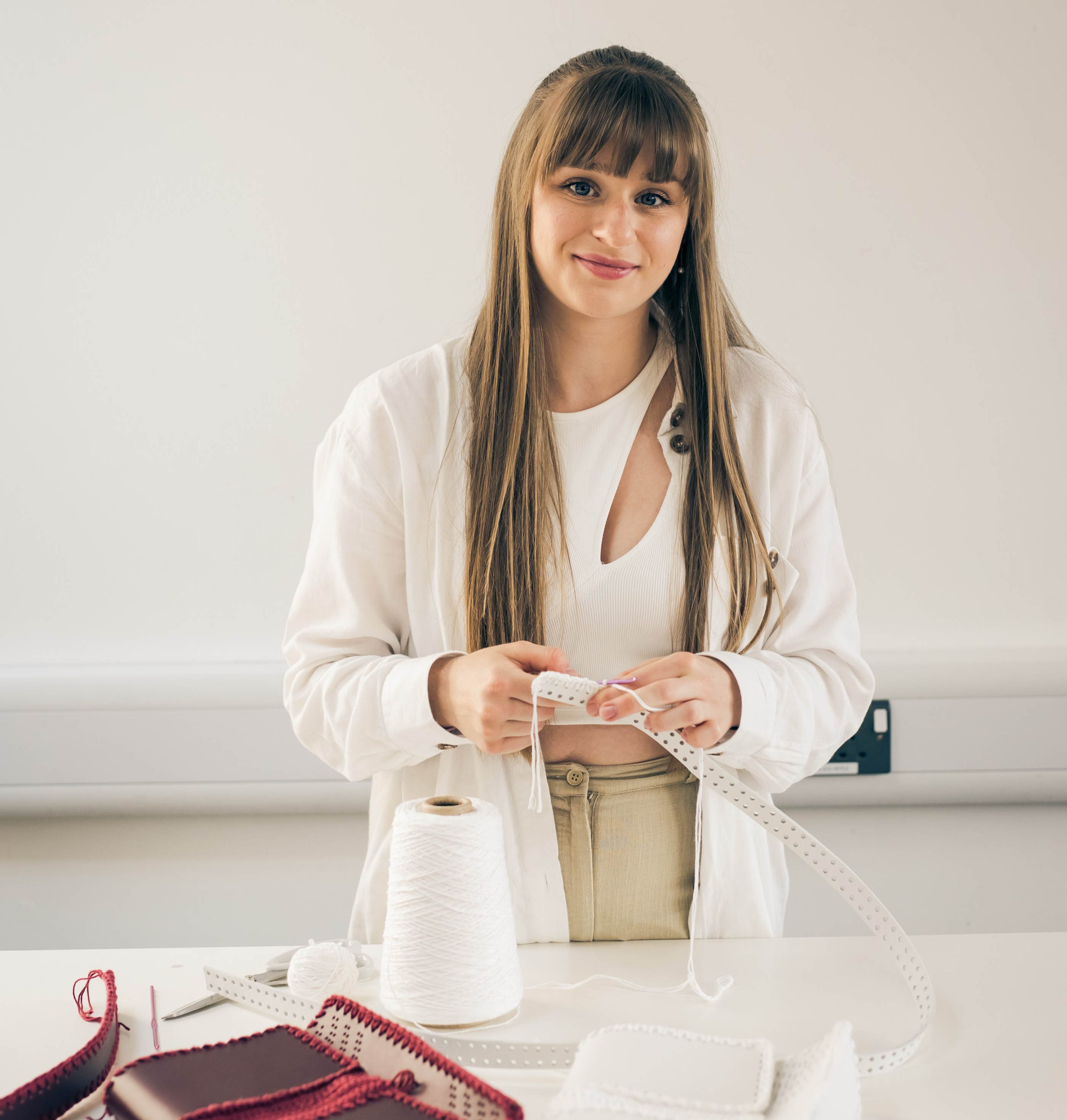 woman dressed in white holding a white leather strap