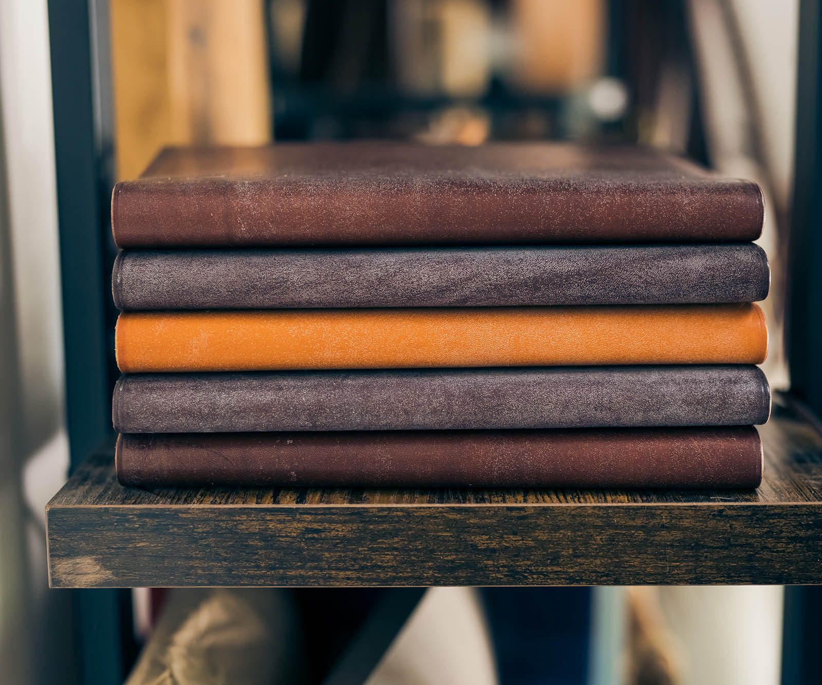 stacked leather bound books on a shelf