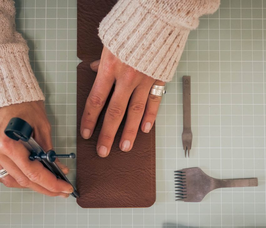 hands working on a piece of leather