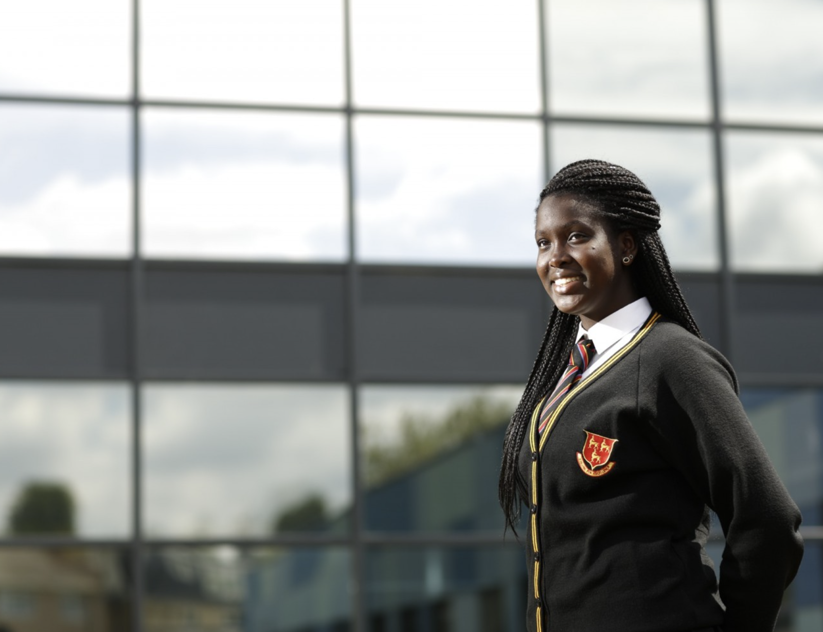 school girl standing outside a glass building