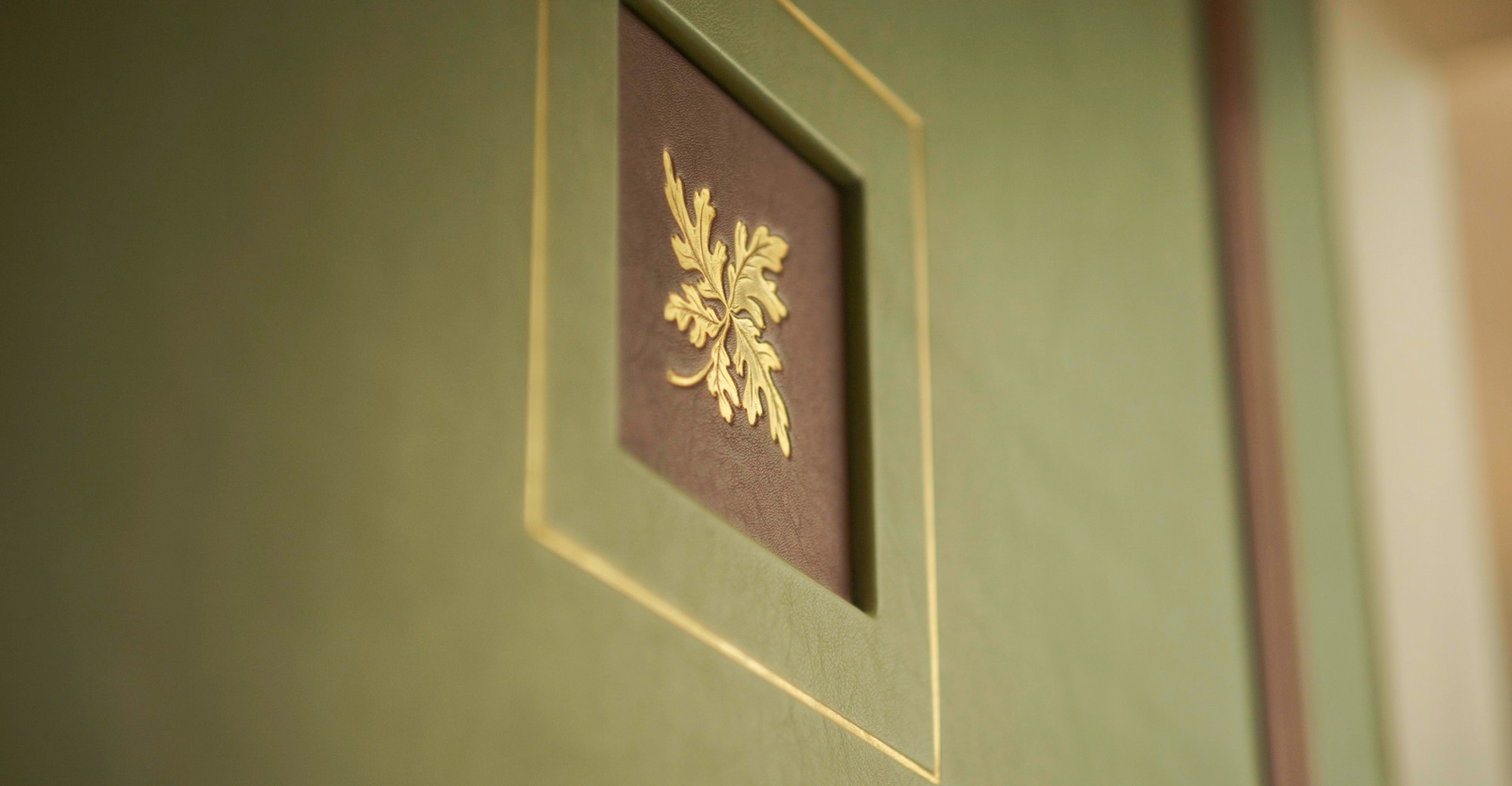 a golden oak leaf on a red background