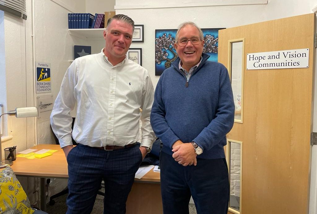two men standing in an office