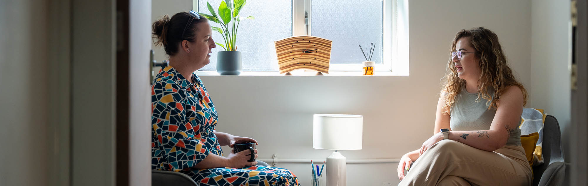 two women talking to each other sitting down
