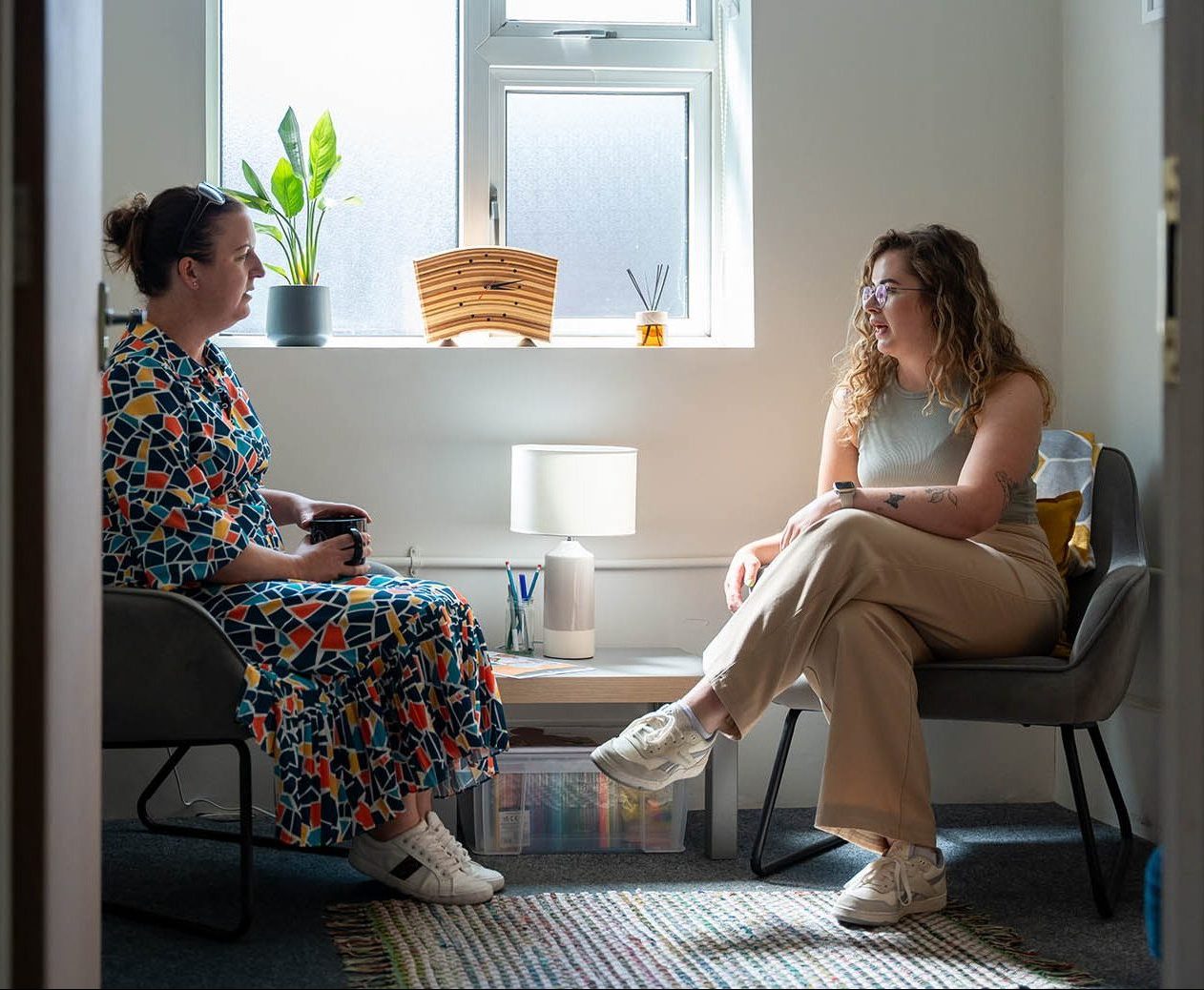 wwo women sitting in chairs opposite each other talking