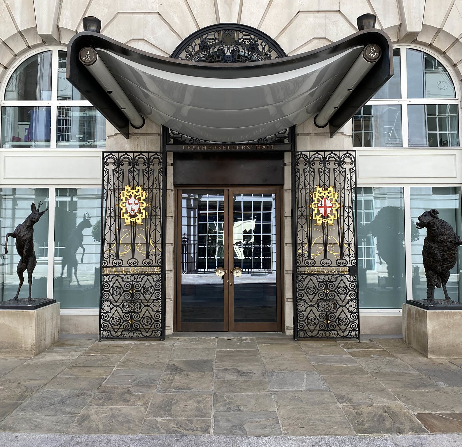 front of a building with canopy and two bronze statues of a roebuck and ram either side