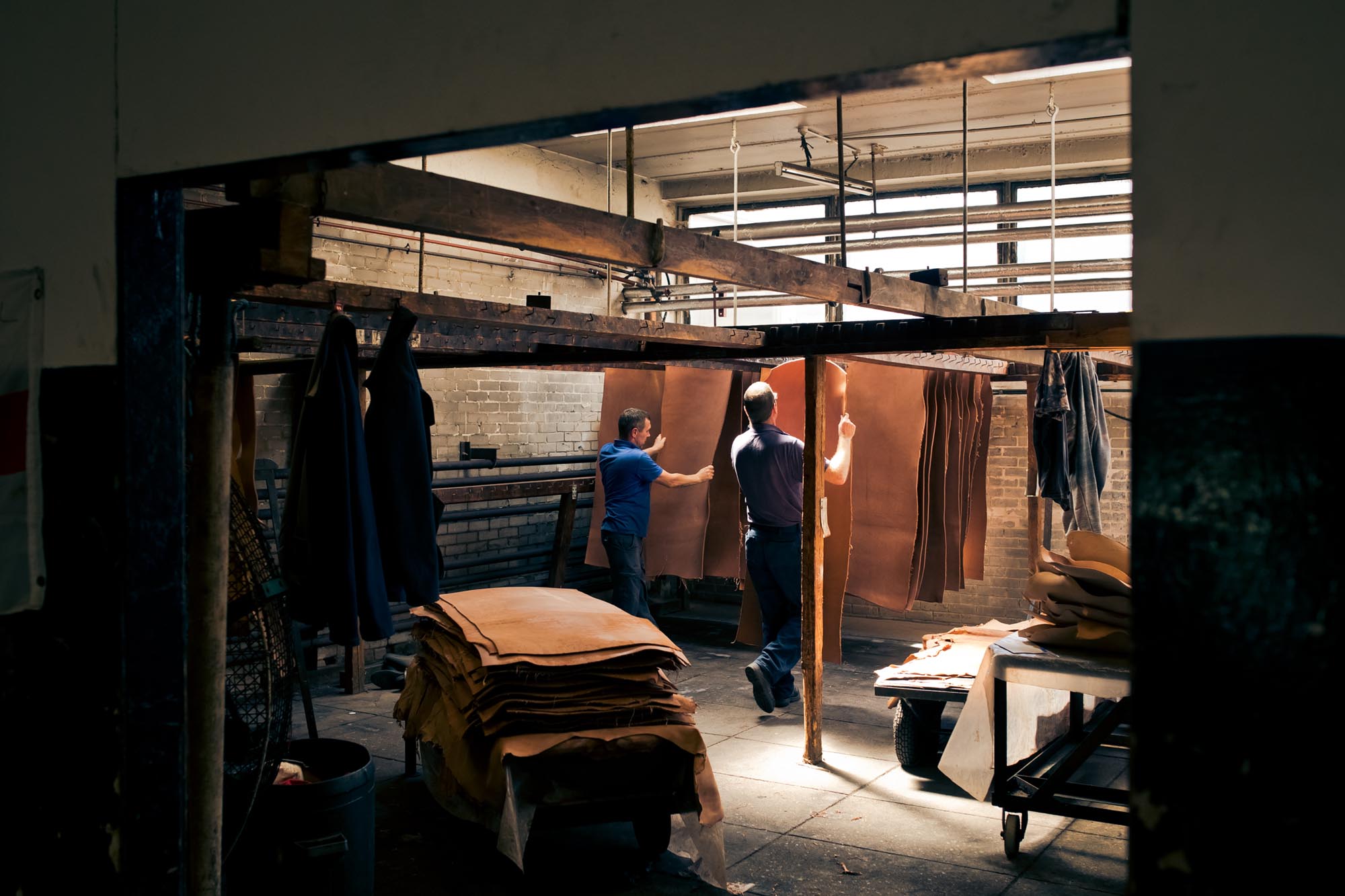 two men working with leather hides