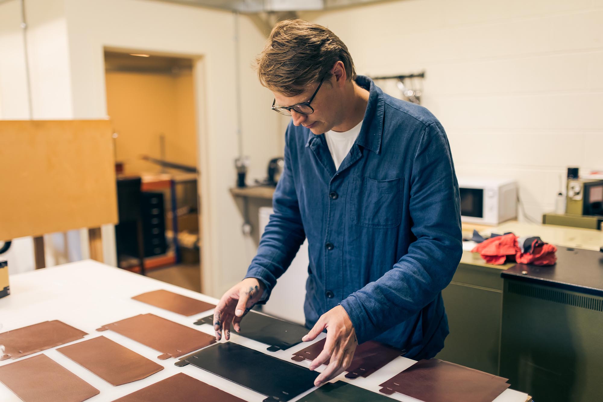 man with pieces of leather on a desk