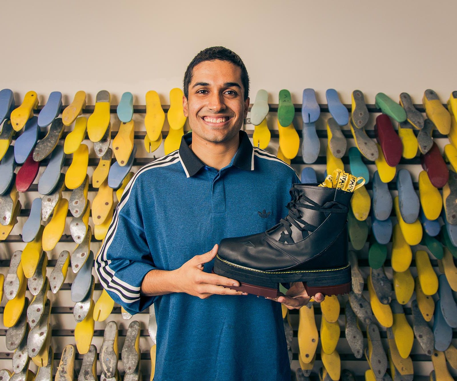 man holding a black leather shoe
