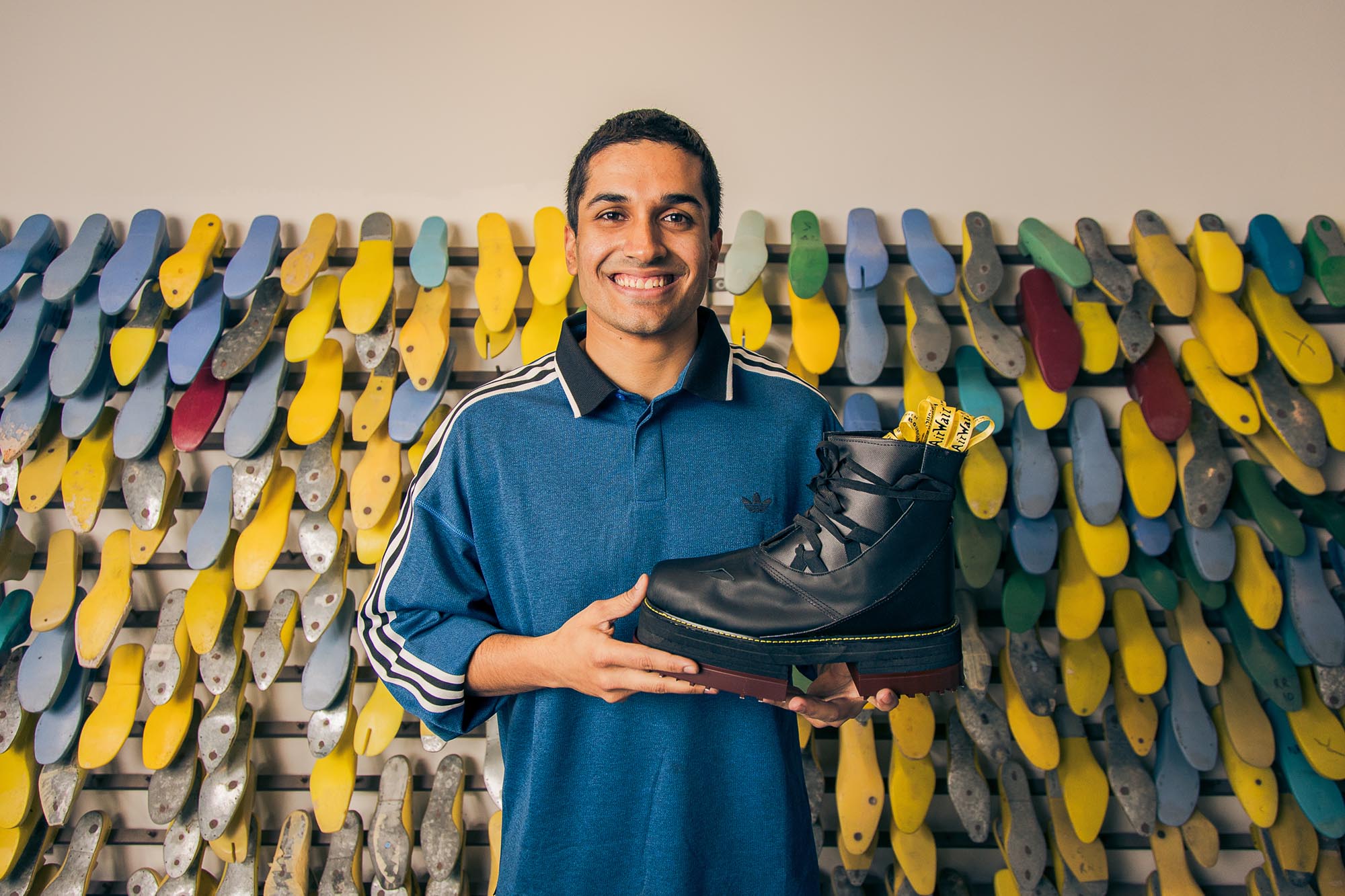 man holding a black leather shoe