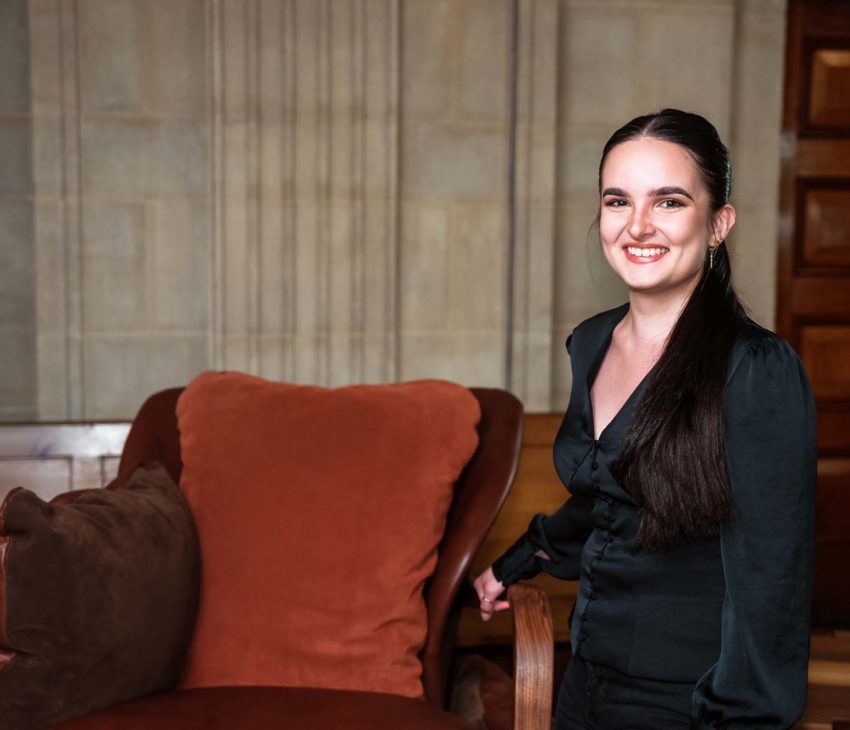 woman standing next to a leather armchair