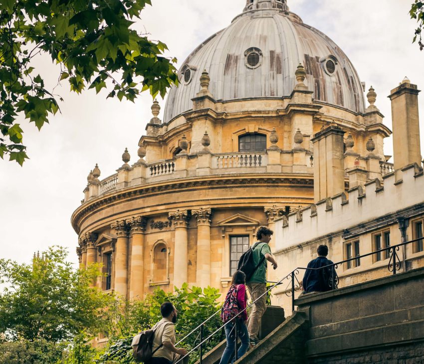 school children walking up stairs with a domed building in the background