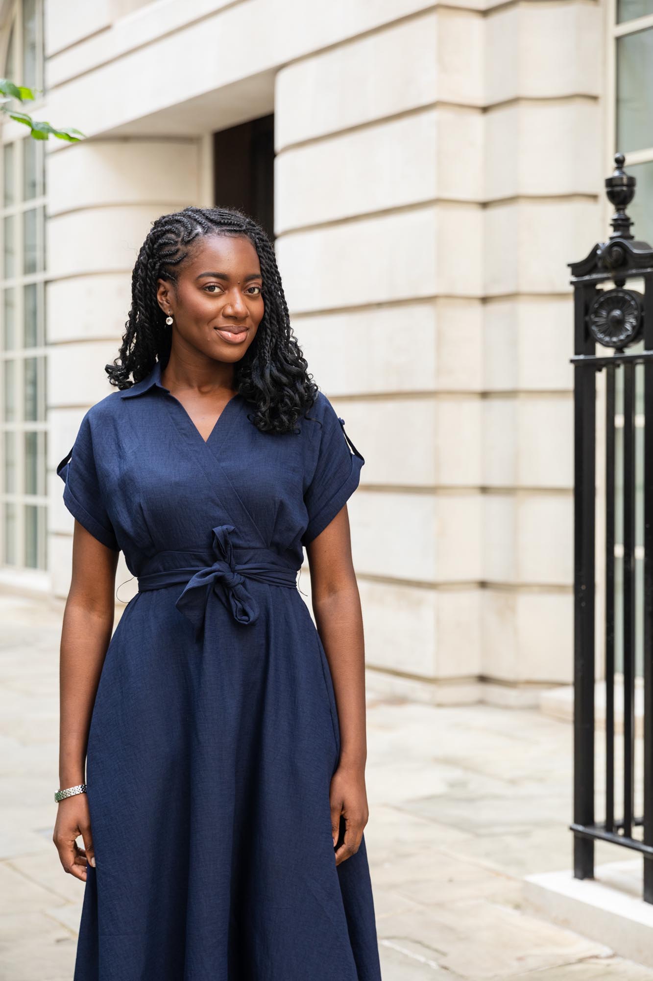 Woman in a blue dress with a stone building in the background