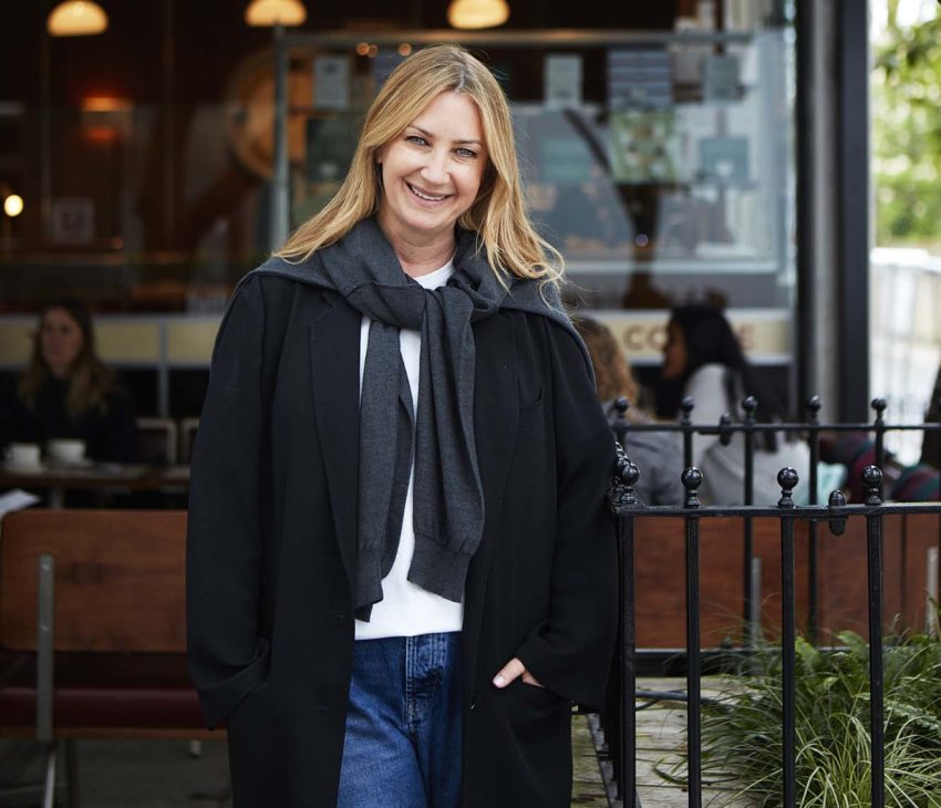 woman in a black coat outside a cafe