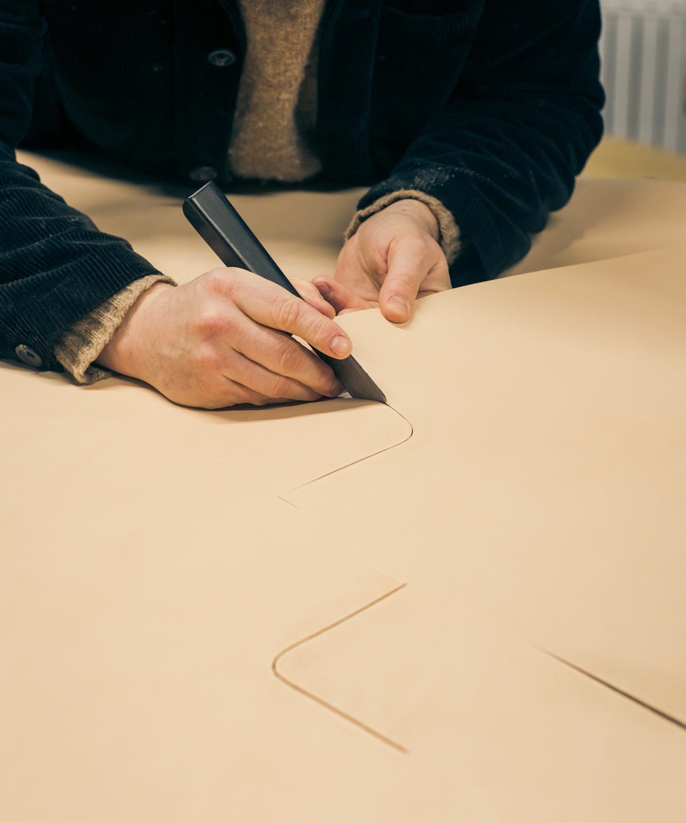 man cutting leather