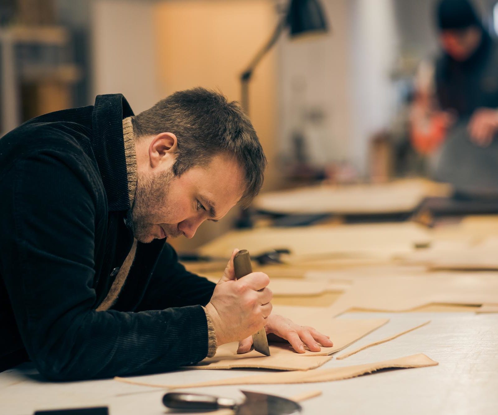 man cutting leather
