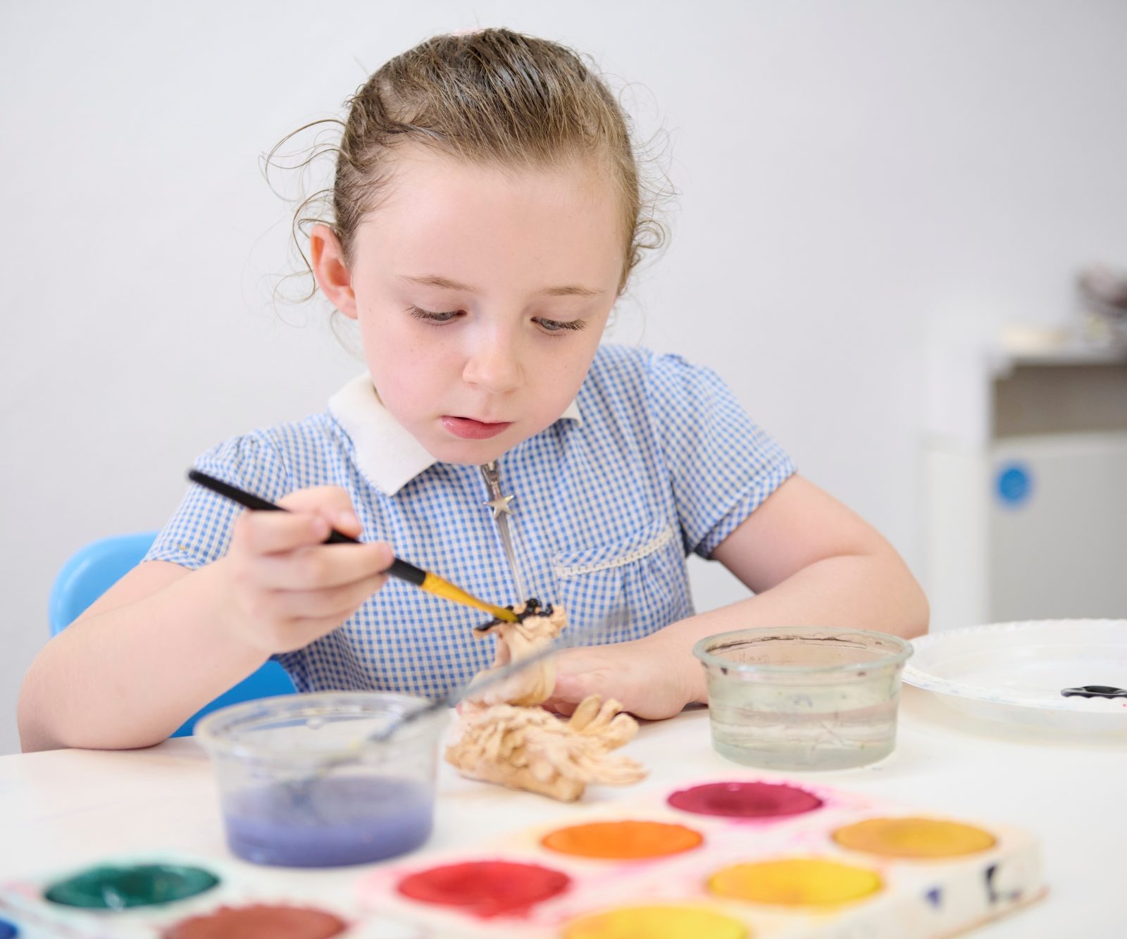 girl painting a clay opbject