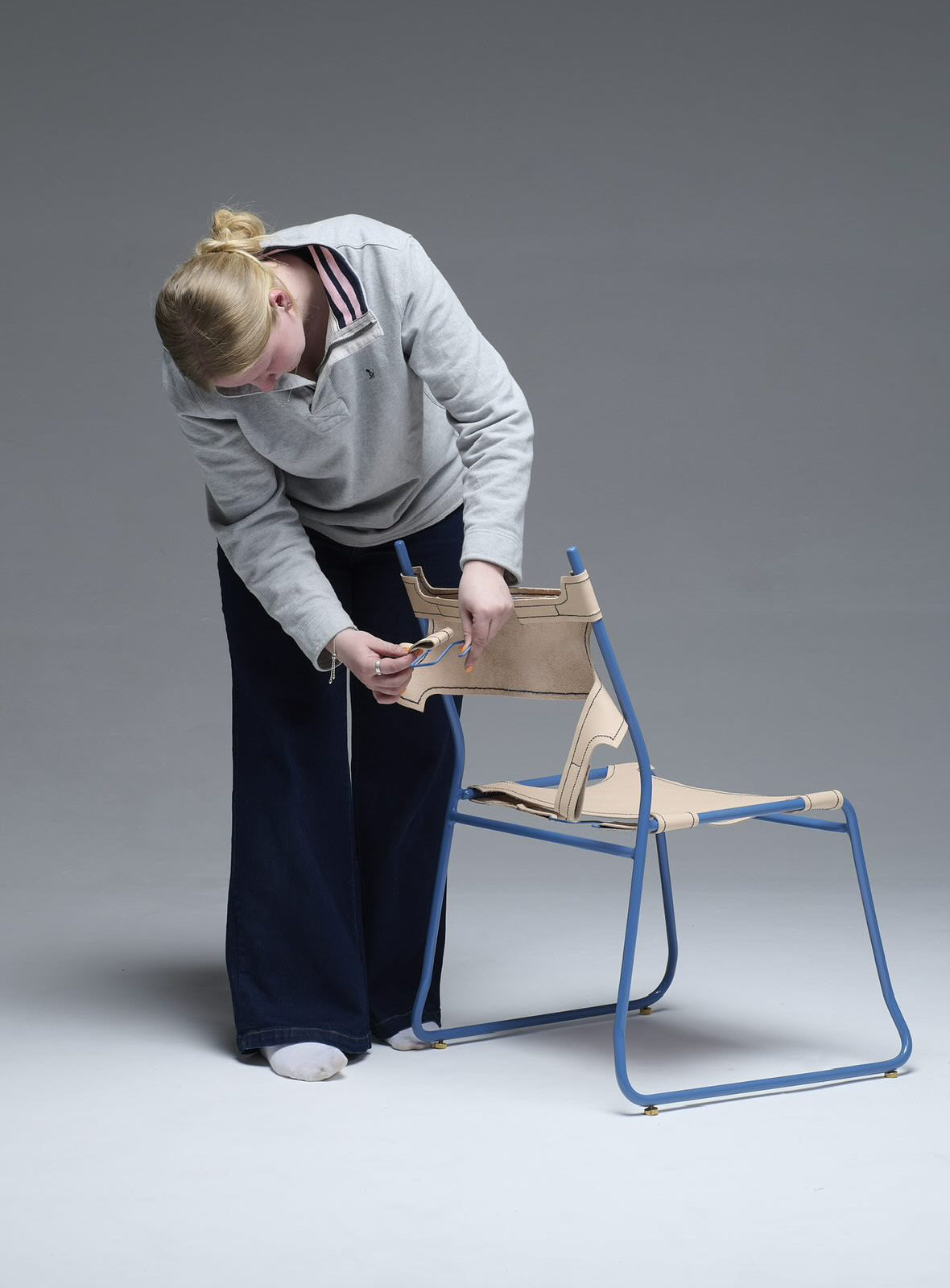 woman adjusting a leather chair