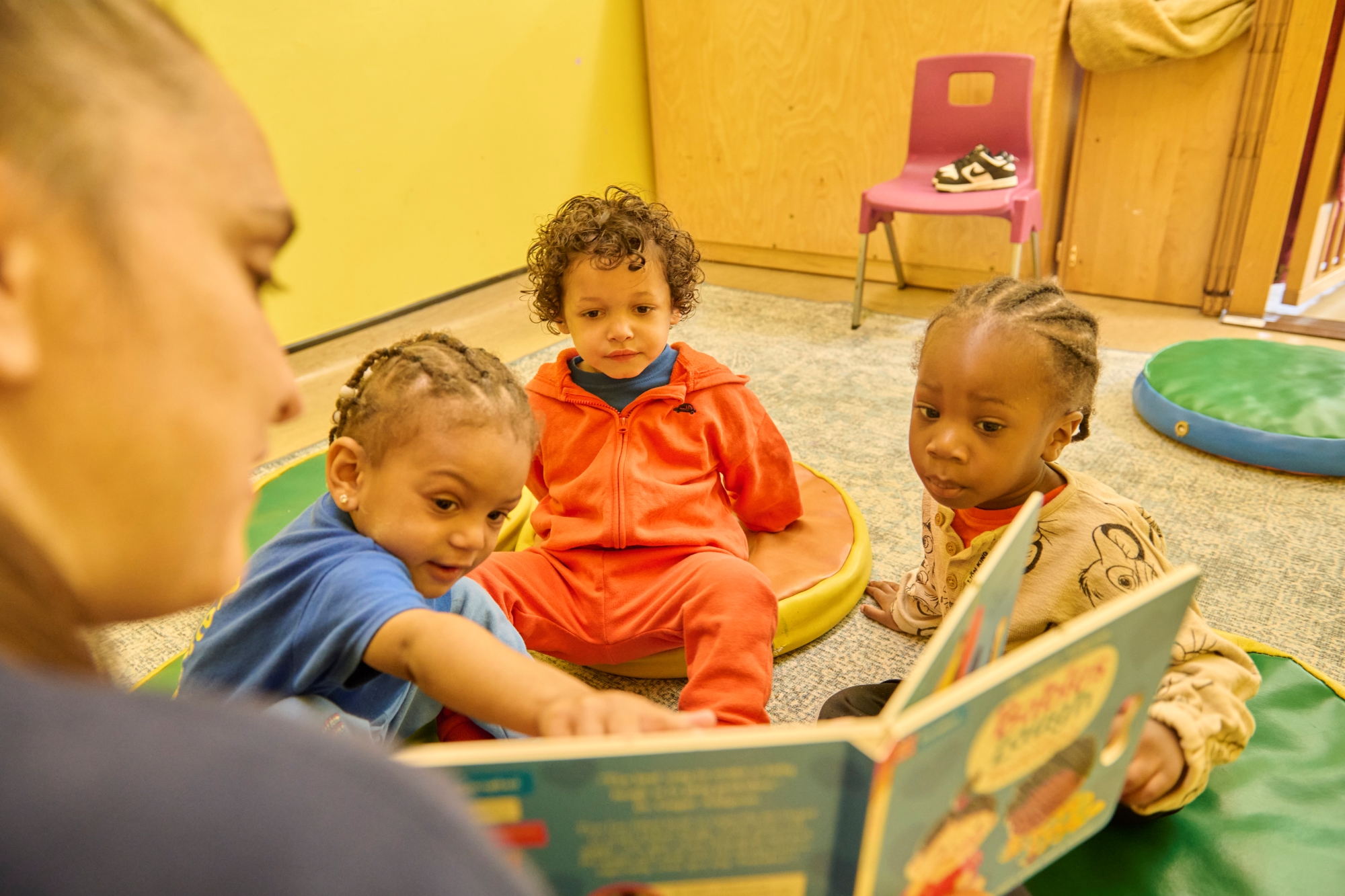 Children look and point at a book