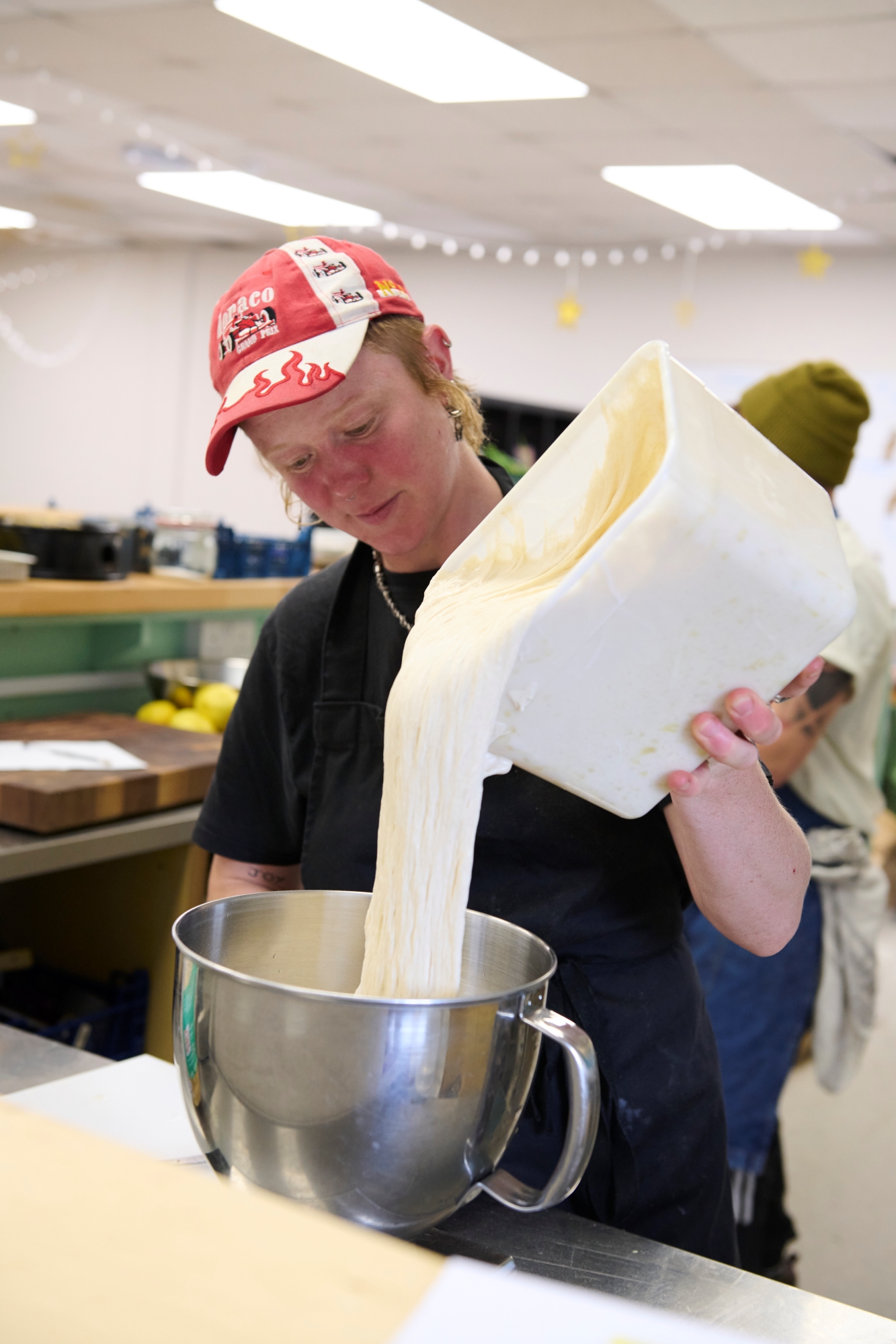 person in hat making dough