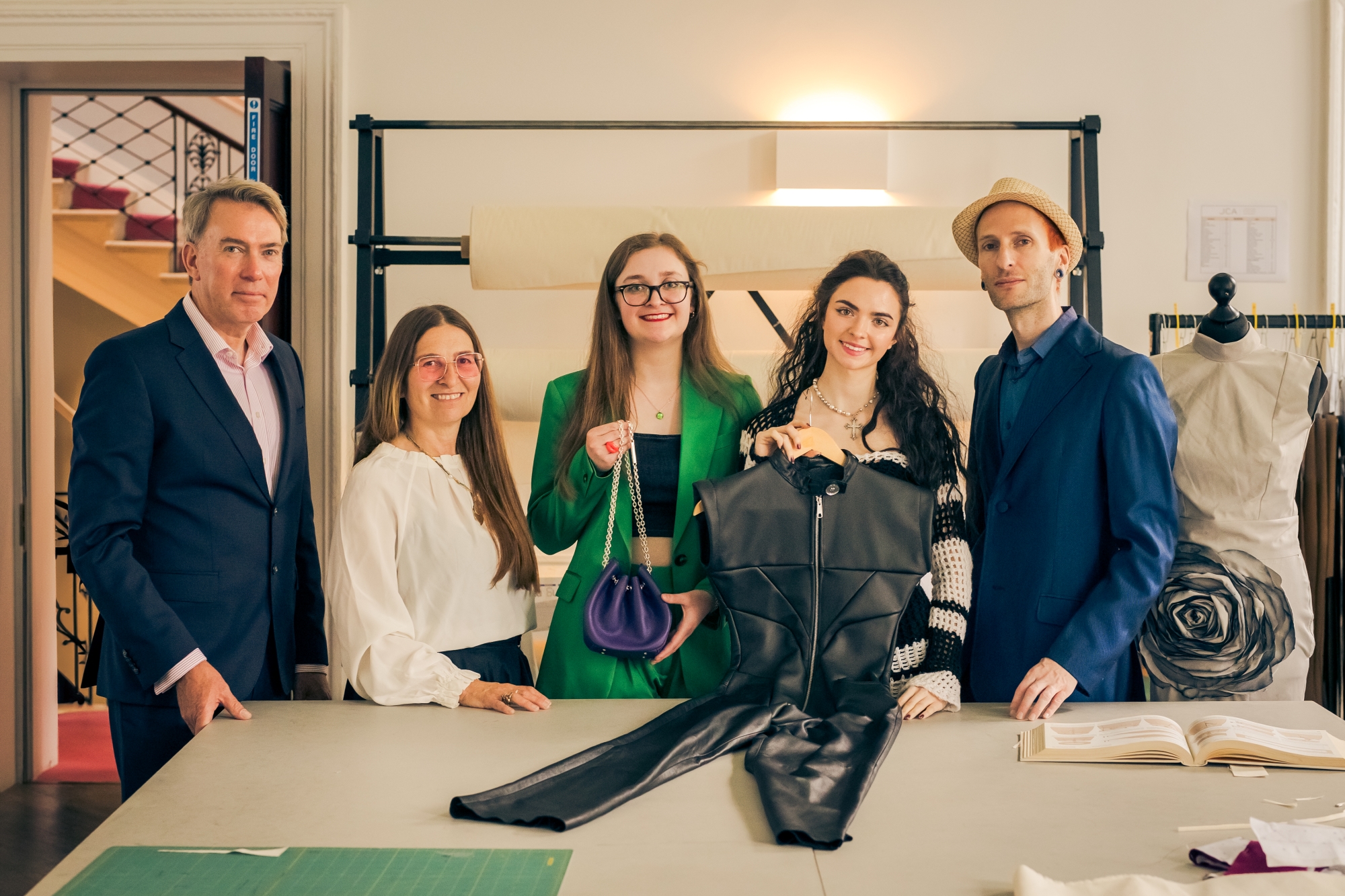 5 people stand in a row in a studio