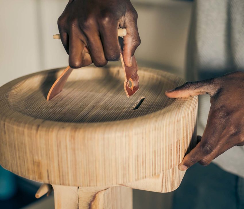 a man holding a leather strap on a piece of furniture