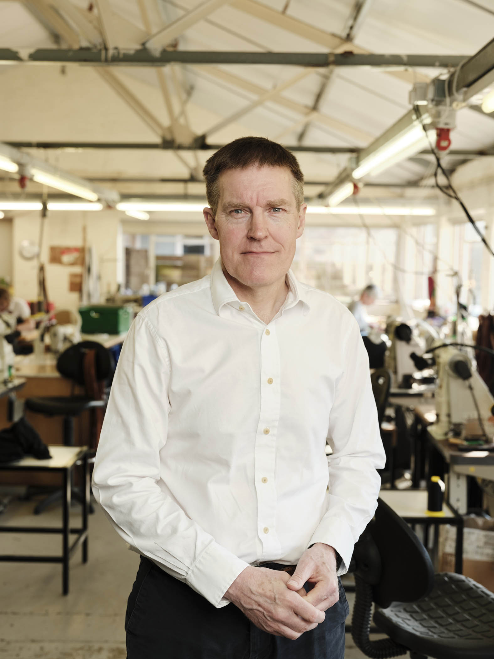 man in a white shirt standing in a factory