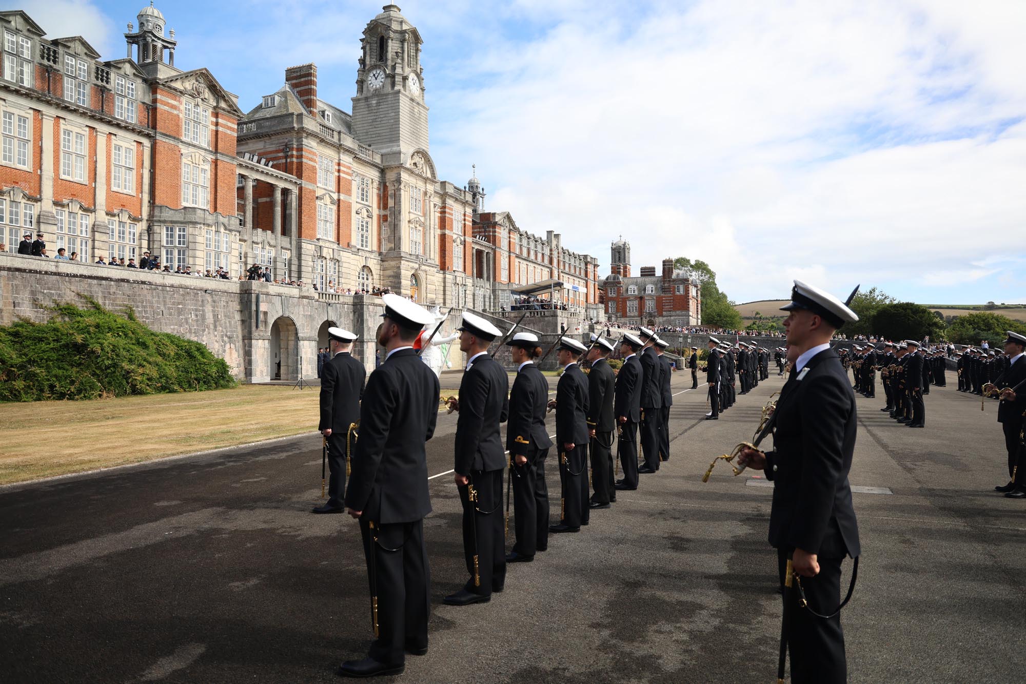 me and women in navy uniforms standing on parade ground