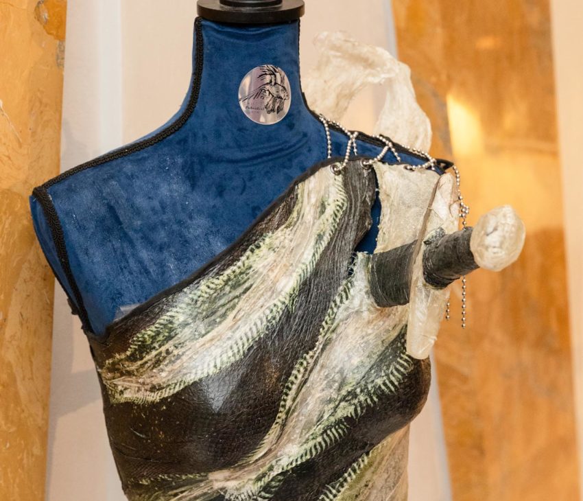 An asymmetrical, sculptural fish skin leather top resembling textured, layered fabric with earthy tones.